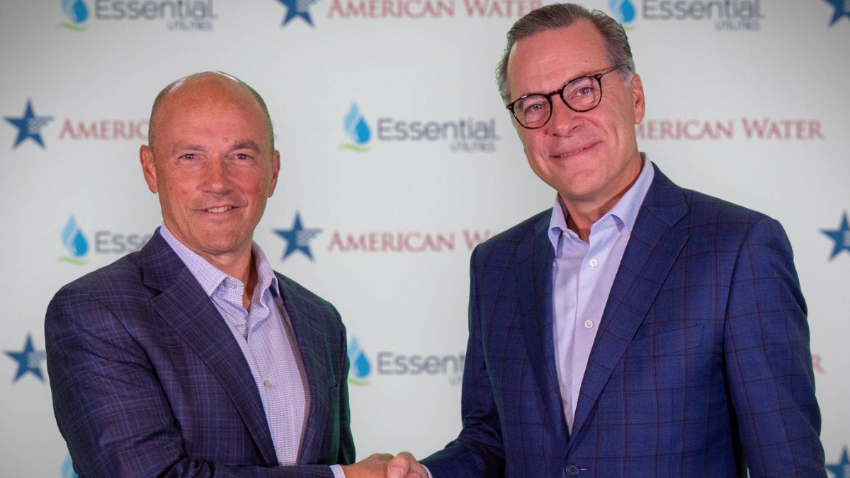 American Water Works and Essential Utilities executives shake hands after announcing planned merger