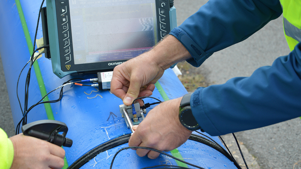 Technicians using digital sensors to detect leaks in a municipal water pipeline