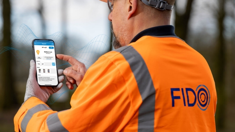 Utility worker using AI leak detection app in the field to identify water pipe leaks