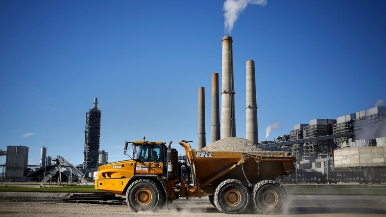 Construction vehicle transporting materials near industrial water infrastructure facility