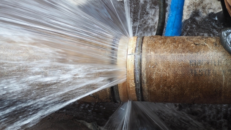 Pressurized water leak from corroded underground pipe connection